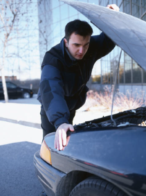 man looking at car engine